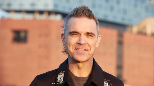 Robbie Williams, britischer S&auml;nger und Songwriter, w&auml;hrend eines Fototermins auf einer Barkasse im Hamburger Hafen. Im Hintergrund ist die Elbphilharmonie zu sehen. - &copy; Georg Wendt/dpa