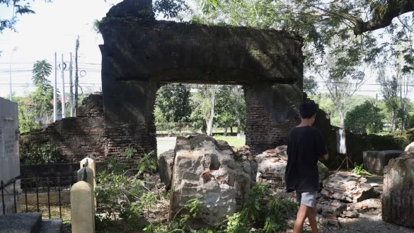 Ein Mann geht nach dem Erdbeben im Norden der Phillippinen an einem besch&auml;digten Mauertor vorbei. - &copy; Uncredited/AP/dpa