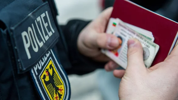 Ein Beamter der Bundespolizei h&auml;lt bei einer Kontrolle ausl&auml;ndische Ausweise in den H&auml;nden. - &copy; Marc M&uuml;ller/dpa