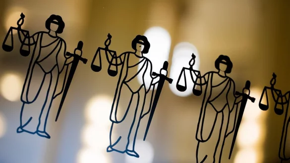 Die Justitia ist an einer Scheibe am Eingang zum Oberlandesgericht zu sehen. - © Rolf Vennenbernd/dpa/Symbolbild