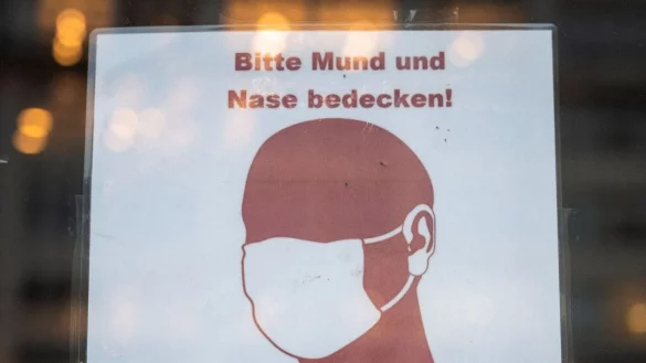 Ein Schild weist in Hamburg auf das Tragen einer Maske hin. - &copy; Daniel Bockwoldt/dpa