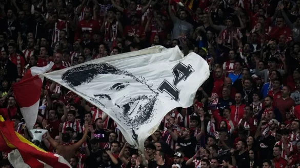 Fans von Atletico Madrid schwenken während des Spiels eine Fahne mit einem Porträt von Gabi. - © Manu Fernandez/AP/dpa