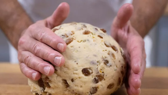 Ein Bäckermeister in Dresden formt einen Teigling zu einem Christstollen. - © Sebastian Kahnert/dpa