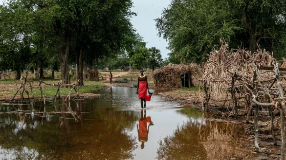 Eine Frau watet durch das Hochwasser zwischen verlassenen Unterk&uuml;nften im Dorf Majak Awar im S&uuml;dsudan. Dort sind ganze Bundesstaaten &uuml;berflutet. Sieben der zehn Klimakrisenherde, die die Nichtregierungsorganisation Oxfam in einer aktuellen Studie identifiziert hat, liegen in Afrika. - &copy; Adrienne Surprenant/AP/dpa