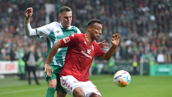 Der Mainzer Karim Onisiwo (r) kommt vor Werders Marvin Ducksch an den Ball. - &copy; Carmen Jaspersen/dpa