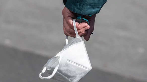 Ein Passant tr&auml;gt eine FFP2-Maske in der Hand. - &copy; Boris Roessler/dpa/Symbolbild