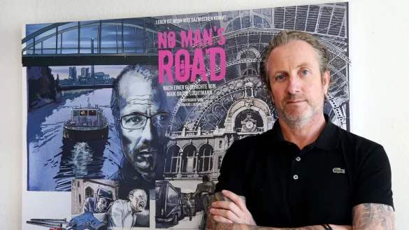 Autor und Regisseur Maik Gro&szlig;e Lochtmann steht vor dem Filmplakat f&uuml;r "No Man\'s Road". - &copy; Roland Weihrauch/dpa