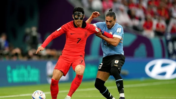 Der S&uuml;dkoreaner Heung-Min Son (l) im Zweikampf mit Uruguays Martin Caceres. - &copy; Mike Egerton/PA Wire/dpa