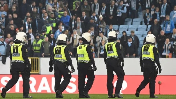 Polizisten gehen w&auml;hrend der Spielunterbrechung &uuml;ber den Platz. - &copy; Matthias Koch/dpa