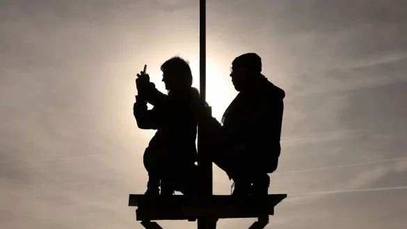 Zwei Demonstranten sitzen auf einem Monopod am Rande des Braunkohle Tagebaus Garzweiler. - &copy; David Young/dpa