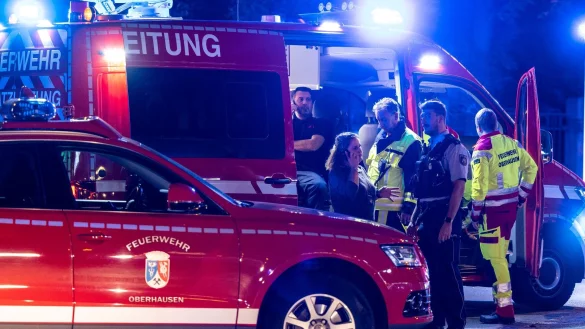 Feuerwehrleute besprechen sich vor einem Fast-Food-Restaurant am Fahrzeug der Einsatzleitung. - © Christoph Reichwein/dpa