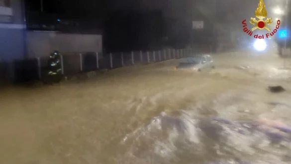 Auf einer &uuml;berfluteten Stra&szlig;e treibt ein Auto in Kalabrien durch die Wassermassen. - &copy; Vigili del Fuoco/dpa