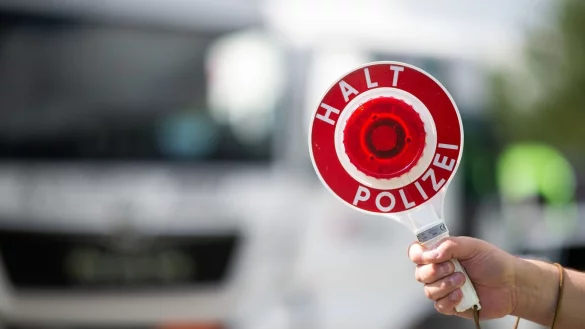 Ein Polizist h&auml;lt bei einer Verkehrskontrolle eine Polizeikelle in der Hand. - &copy; Jonas G&uuml;ttler/dpa/Symbolbild