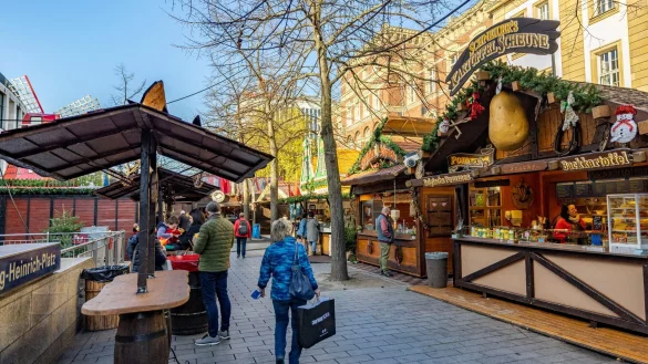 Menschen laufen über den Duisburger Weihnachtsmarkt. - © Christoph Reichwein/dpa