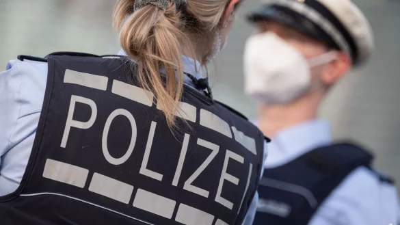 Eine Polizistin und ein Polizist mit FFP2-Maske stehen sich gegen&uuml;ber. - &copy; Marijan Murat/dpa/ZB