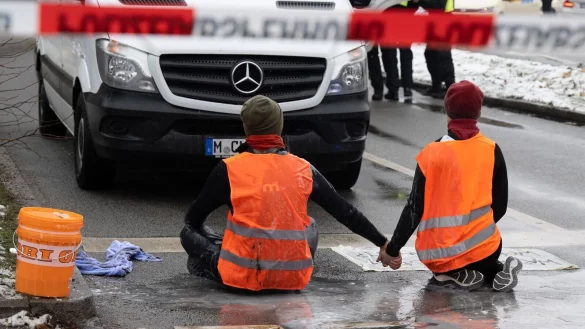 Zwei Klimaaktivisten w&auml;hrend einer Protestaktion der Gruppe "Letzte Generation" in M&uuml;nchen. - &copy; Peter Kneffel/dpa