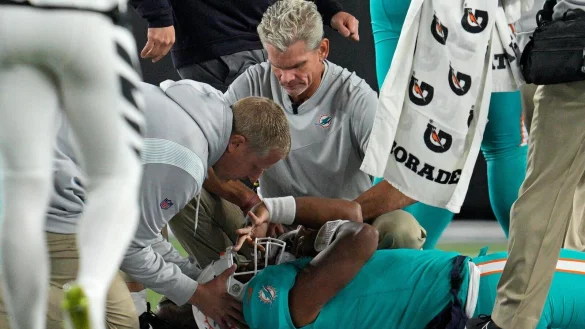 Dolphins-Quarterback Tua Tagovailoa wird auf dem Feld liegend untersucht. - &copy; Jeff Dean/AP/dpa