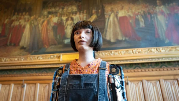 Roboter Ai-da steht vor einem Gem&auml;lde in den Houses of Parliament, bevor er als erster Roboter Fragen im britischen Parlament beantwortet. - &copy; Stefan Rousseau/PA Wire/dpa