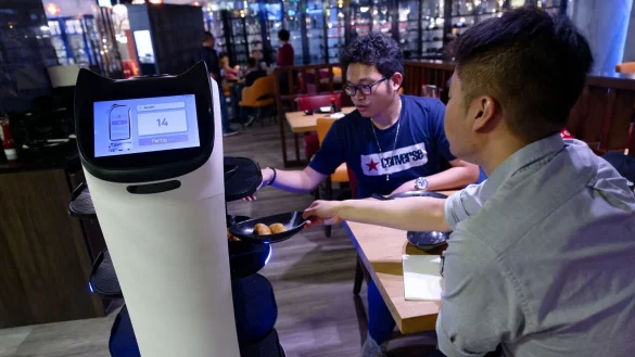 G&auml;ste nehmen im K&ouml;lner Sushi-Restaurant Nakoyashi ihre Speisen aus dem Serviceroboter Miaomiao. - &copy; Henning Kaiser/dpa