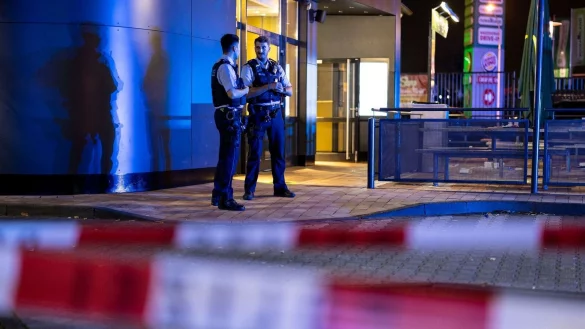 Zwei Polizisten vor einem Fast-Food-Restaurant in Oberhausen, in dessen Außenbereich Schüsse gefallen waren. - © Christoph Reichwein/dpa