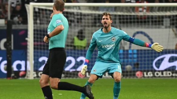 Schiedsrichter Sascha Stegemann (l) verwarnt Frankfurts Torwart Kevin Trapp. - &copy; Arne Dedert/dpa