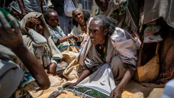 Eine &auml;thiopische Frau streitet mit anderen &uuml;ber die Verteilung von gelben Spalterbsen, nachdem diese von einer Hilfsorganisation in der Region Tigray verteilt worden waren. - &copy; Ben Curtis/AP/dpa