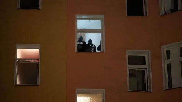 Polizten sind am Morgen im Treppenhaus eines Wohnhauses zu sehen. - &copy; Paul Zinken/dpa