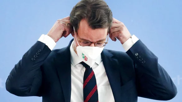 Der nordrhein-westf&auml;lische Ministerpr&auml;sident Hendrik W&uuml;st (CDU), setzt sich eine Corona-Schutzmaske auf. - &copy; Roland Weihrauch/dpa/Archivbild