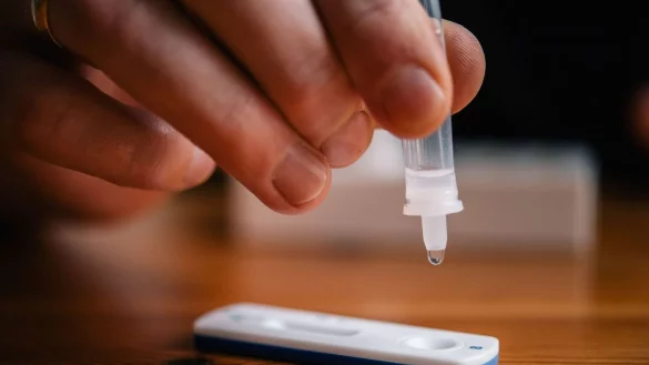 Ein Mann tr&auml;ufelt eine L&ouml;sung auf eine Testkassette f&uuml;r einen Corona-Schnelltest. - &copy; Zacharie Scheurer/dpa/Symbolbild