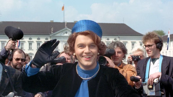 Verkleidet als K&ouml;nigin Beatrix winkt der deutsche Komiker und Showmaster Hape Kerkeling vor Schloss Bellevue f&uuml;r die Presse. (Archivfoto von 1991) - &copy; picture alliance / dpa