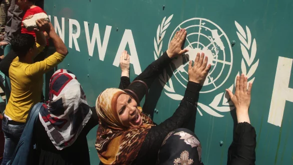 Pal&auml;stinenserinnen vor UNRWA-Schild (Archivbild) - &copy; Ashraf Amra/APA Images via ZUMA Wire/dpa