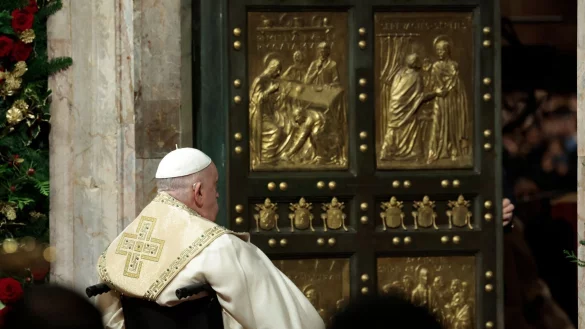 Im stillen Gebet sitzt Franziskus vor der Heiligen Pforte. - © Remo Casilli/Pool Reuters/AP/dpa