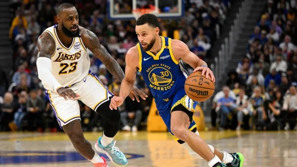 LeBron James (l) und die Los Angeles Lakers setzten sich bei den Golden State Warriors um Stephen Curry durch. - © Eakin Howard/AP/dpa