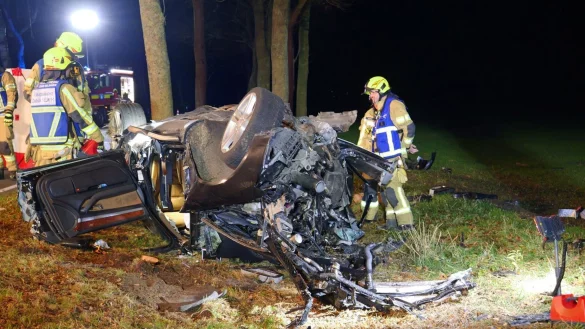 Einsatzkräfte stehen an dem völlig demolierten Auto. - © Ralph Meyer/dpa