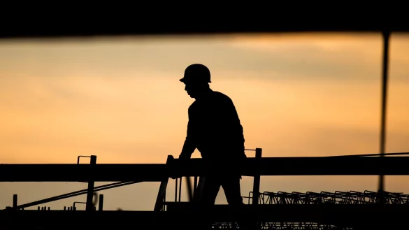 Ein Bauarbeiter in der Morgendämmerung. Laut Ifo-Beschäftigungsbarometer wollen viele Unternehmen Personal abbauen, in der Baubranche zeichnet sich jedoch keine größere Entlassungswelle ab. - © Julian Stratenschulte/dpa