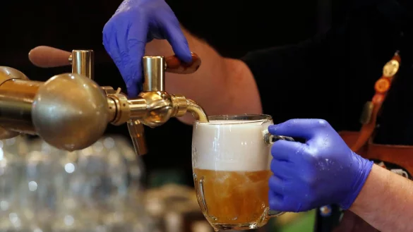 Ein Barkeeper zapft ein Bier auf einer Restaurant-Terrasse. (Symbolbild) - &copy; Petr David Josek/AP/dpa