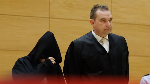 David Volke (r), der Verteidiger der Angeklagten, steht neben seiner Mandantin in einem Saal des Landgerichts zum Auftakt im Prozess um ein getötetes Baby. (Archivbild) - © Friso Gentsch/dpa