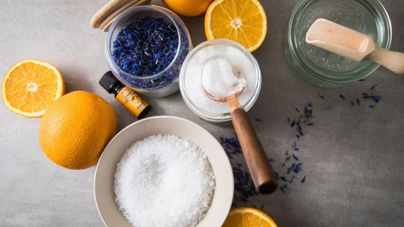 F&uuml;r das Badesalz braucht man: Meersalz, Kokos&ouml;l, &auml;therisches &Ouml;l und zur Dekoration getrocknete Blumen und ein sch&ouml;nes Gef&auml;&szlig;. - &copy; Christin Klose/dpa-tmn