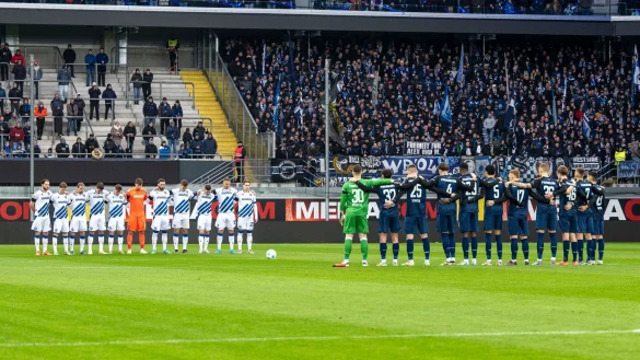 Gedenkminute der Mannschaften vor dem Anpfiff. - © David Inderlied/dpa