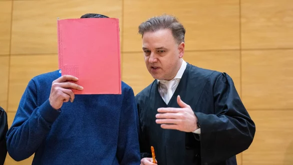 Einer der Angeklagten (l) steht mit seinem Anwalt Burkhard Benecken beim Beginn des Prozesses um den Totschlag nach einer Abifeier in Bad Oeynhausen vor dem Landgericht. - © Guido Kirchner/dpa