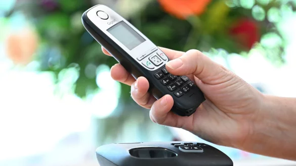 ILLUSTRATION - Eine Frau hölt ein Festnetz-Telefon in ihrer Hand. - © Bernd Weissbrod/dpa