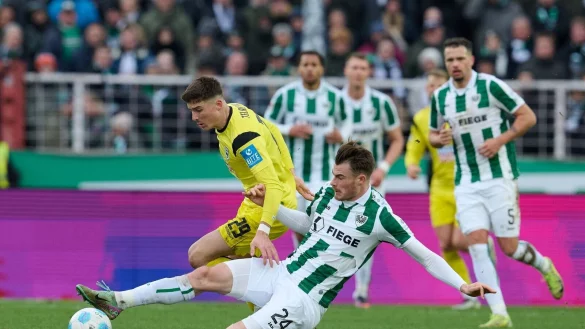 Münsters Niko Koulis verhindert eine Chance des Ulmers Semir Telalovic (l). - © Bernd Thissen/dpa