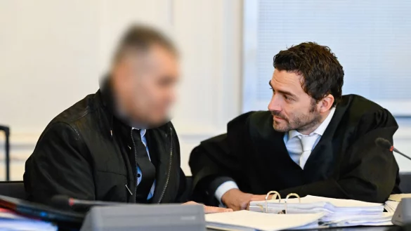 Der Angeklagte spricht im Verhandlungssaal mit seinem Anwalt. - © Uwe Anspach/dpa