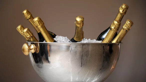 Wer viele Gäste hat, legt am besten gleich ein paar Sektflaschen bereit. In einem mit Eis gefüllten Gefäß kühlen die Flaschen auch innerhalb kurzer Zeit schnell herunter. - © Tobias Hase/dpa/dpa-tmn
