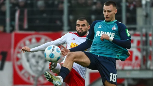 Der Kölner Tim Lemperle (rechts) und Robin Ziegele von Regensburg kämpfen um den Ball. - © Armin Weigel/dpa
