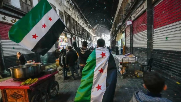 Anhänger der Opposition tragen Oppositionsfahnen. - © Hussein Malla/AP/dpa