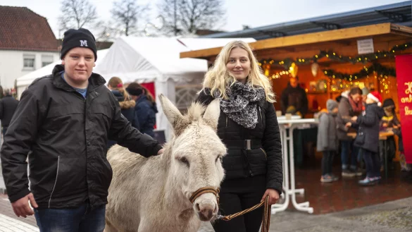 Felix Prante und Pia Erfkamp vom landwirtschaftlichen Verein k&uuml;mmern sich w&auml;hrend des Weihnachtsmarktes um Esel Olli, der den Trubel gelassen nimmt. - &copy; Laurenz Tegethoff