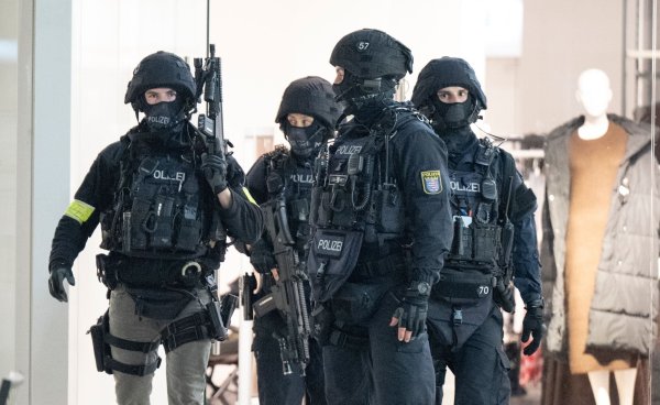 Schwer bewaffnete Polizisten durchkämmen das Nordwestzentrum in Frankfurt. - © Boris Roessler/dpa