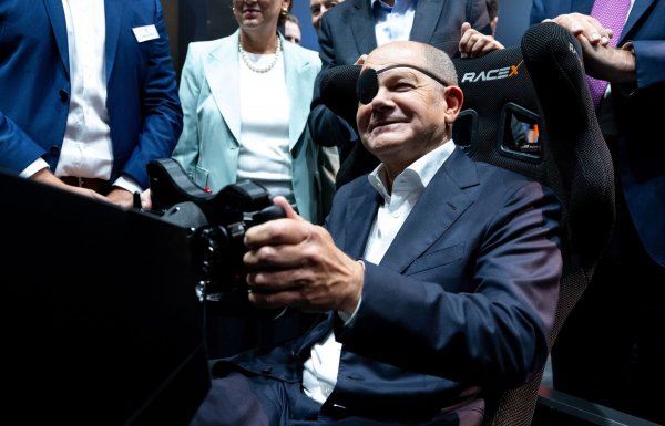 Der Bundeskanzler steuert: Olaf Scholz auf der IAA in einem Autosimulator. - © Sven Hoppe/dpa POOL/dpa