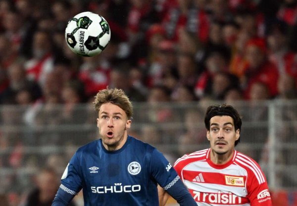 Bielefelds Kunze (l.) und Union Leite (r.) visieren den Ball an. - © Soeren Stache/dpa